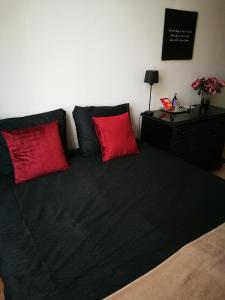 een bed met twee rode kussens erop bij En Suite in Den Haag