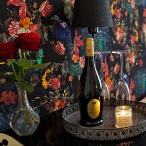 una botella de vino sentada en una mesa con una lámpara en En Suite en The Hague