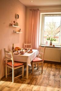 una sala da pranzo con tavolo, sedie e finestra di Fewo Pöhlbergblick Wolkenstein a Wolkenstein