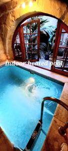 una piscina con un celular en el agua en Il Mithna farmhouse with indoor heated jacuzzi pool en Għarb