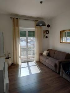 ein Wohnzimmer mit einem Sofa und einer Glasschiebetür in der Unterkunft Casa Vacanze Celine a due passi dal mare in Savona
