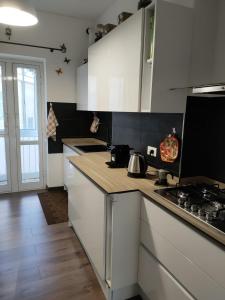 una cucina con armadi bianchi e piano cottura di Casa Vacanze Celine a due passi dal mare a Savona