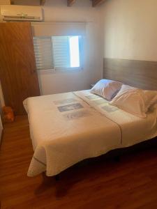 1 dormitorio con 1 cama grande y cabecero de madera en rosarigasino en Rosario