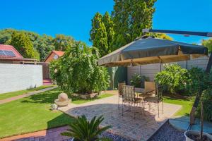 a patio with a table and an umbrella at The Lemon Tree Oasis - Solar in Centurion