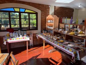 a kitchen with several tables of food on display at Pousada da Brigida in Campos do Jordão