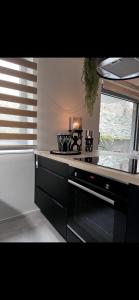 a kitchen with a stove top oven next to a window at L’Agathe in Liège