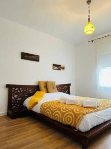 1 dormitorio con 1 cama grande con sábanas blancas y amarillas en Ca la Carme, en Santa Pau