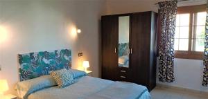 a bedroom with a bed and a wooden cabinet at Iam Villaverde in La Oliva