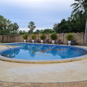 a large swimming pool with chairs around it at Casa 17 Lençóis Maranhenses - Barreirinhas - MA in Barreirinhas