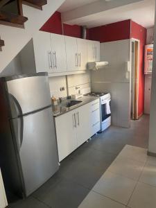 a kitchen with white cabinets and a stainless steel refrigerator at rosarigasino in Rosario