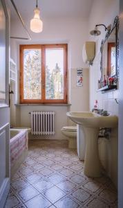 baño con lavabo y aseo y ventana en La Trifoglietta, en Cetona