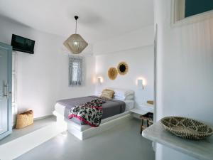 um quarto com uma cama num quarto branco em Ariti Seaside Residence em Naousa