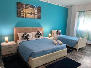 een slaapkamer met 2 bedden en een blauwe muur bij Mestre Residence in Mestre +23 foto's