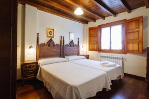a bedroom with two beds and a window at Apartamentos Porcia in Tapia de Casariego