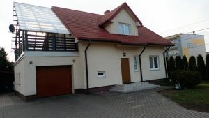 a white house with a red roof and a garage at Dom na Konwaliowej in Narew