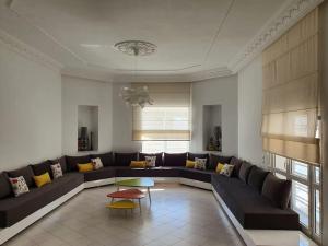 ein Wohnzimmer mit einem Sofa und einem Tisch in der Unterkunft La villa de la mer in Sidi Bou Jobline