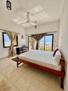 Jambiani White Sands Bungalows في جامبياني: غرفة نوم مع سرير وإطلالة على المحيط