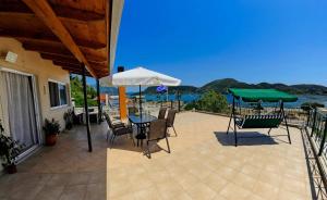 a patio with a table and chairs and an umbrella at Irene home in Vlikhón