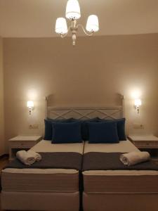 a bedroom with a large bed with blue pillows at Dionisia apartments 8 in Kos