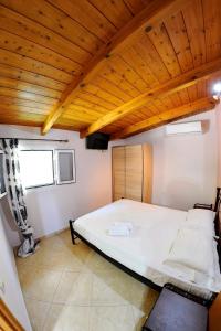Vlikhón的住宿－Irene home，一间卧室设有一张带木制天花板的大床
