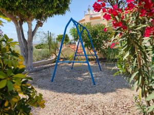 Un columpio azul en un patio con flores en Cortijo ZD, en Mojácar