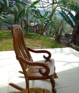 a wooden rocking chair sitting on top of a porch at Butterfly in Tajo Alto