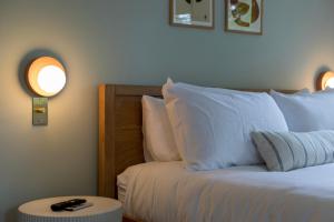 1 dormitorio con cama con almohadas blancas y mesa en The Grandview Collection - FL Ave en West Palm Beach