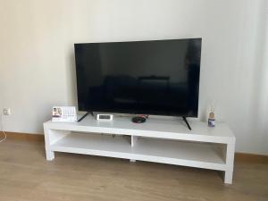 a flat screen tv sitting on a white entertainment center at Pearl - new and cosy apartment close to Center in Rīga