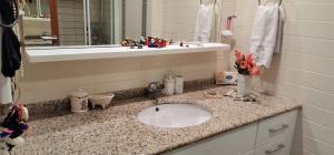 een badkamerbar met een wastafel en een spiegel bij Luxe Residence next to Water Garden Open Mall, International Financial Center & Medical Center in Istanbul