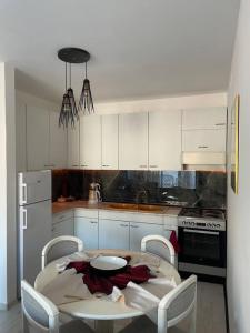 a kitchen with a table and chairs and a kitchen with white cabinets at Penthouse with castle view in Prizren