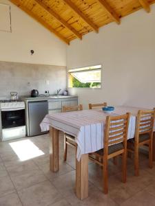 a kitchen with a large wooden table and chairs at Cabaña Maca Tobiano in El Calafate