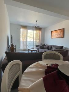 a living room with a couch and a table and chairs at Penthouse with castle view in Prizren