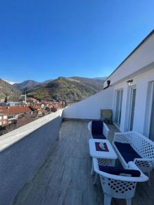a balcony with chairs and a view of a city at Penthouse with castle view in Prizren