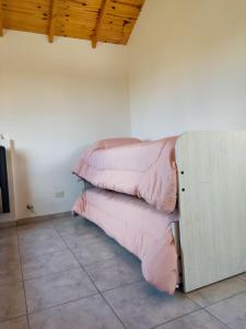 una pila de almohadas rosas en una habitación en Cabaña Maca Tobiano en El Calafate