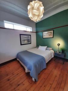 a bedroom with a large bed and a chandelier at Oppikoppi in Melville in Johannesburg