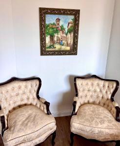 ベニドルムにあるGaray Apartmentsの壁画のある部屋の椅子2脚