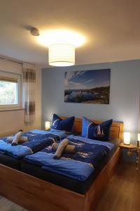 dos personas tumbadas en una cama con sábanas azules en Dat Niehuus Tarnewitz en Boltenhagen