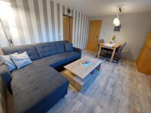 een woonkamer met een blauwe bank en een tafel bij Dat Niehuus Tarnewitz in Boltenhagen