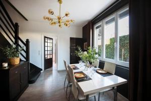 a dining room with a table with chairs and a chandelier at Jolie Maison sur Orléans, Parking & Climatisation in Orléans