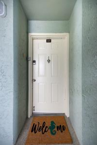 a welcome mat in front of a white door at Sandcastle North Unit #403 in Clearwater Beach