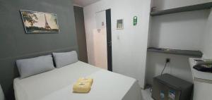 a bedroom with a white bed with a bag on it at Casa Aeroporto Pousada in Recife
