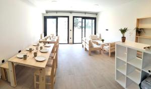 a dining room with wooden tables and chairs at Albergue turístico Anam Cara House in Serantes