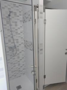 una ducha con puerta de cristal en un baño en Anam Cara House, en Serantes
