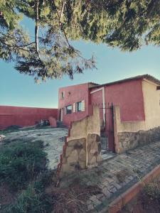 ein rotes Gebäude mit einem Tor davor in der Unterkunft Maison de campagne dans un domaine viticole in Tautavel