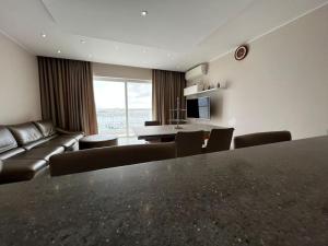 ein Wohnzimmer mit einem Tisch, Stühlen und einem Sofa in der Unterkunft Marsaxlokk SeaView 2 Bedroom Penthouse in Marsaxlokk