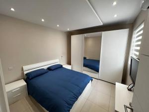 ein Schlafzimmer mit einem blauen Bett und einem Spiegel in der Unterkunft Marsaxlokk SeaView 2 Bedroom Penthouse in Marsaxlokk