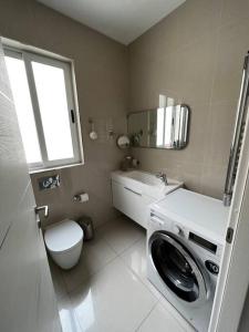 ein Badezimmer mit einer Waschmaschine und einem WC in der Unterkunft Marsaxlokk SeaView 2 Bedroom Penthouse in Marsaxlokk