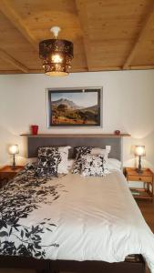 ein Schlafzimmer mit einem Bett mit einem Bild an der Wand in der Unterkunft Gîte Le Logis Vallat haut in Fuveau