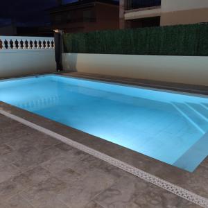 Casa Empordà con piscina exclusiva في Báscara: حمام سباحة كبير مع أضواء زرقاء على الأرض