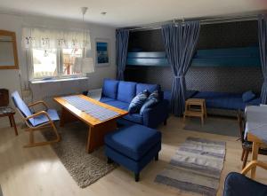 a living room with a blue couch and a table at Cottage Båstad/Bjäre in Båstad